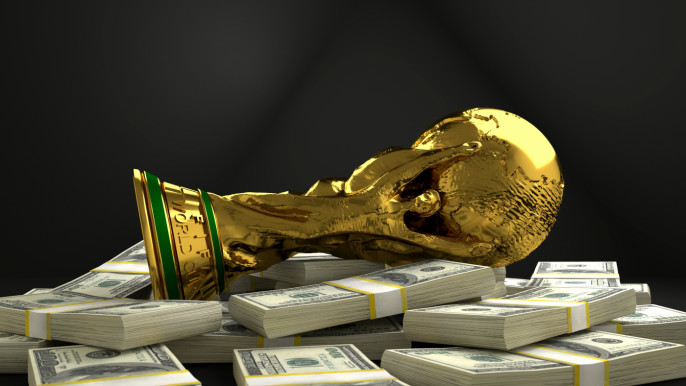 The FIFA World Cup trophy lying on a pile of dollars